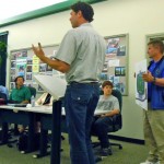 Don Borges, right, holds a rendering of the football while architect Brett Long talks about it. Photo/Kathryn Reed