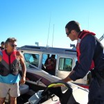 Coast Guard Petty Officer Kyle Rahn, right, inspects Kelly Rogers boat. 