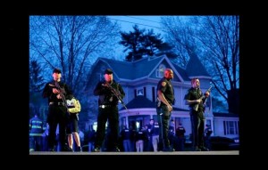 Police officers guard the entrance to Franklin Street where there was an active crime scene search for the suspect in the Boston Marathon bombings. Photo/Matt Rourke/Associated Press