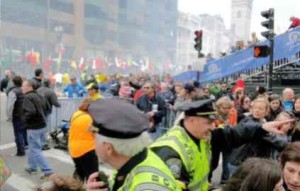 People scramble for cover after two explosions go off at the Boston Marathon.