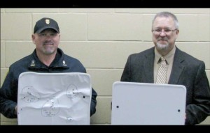 Cold Spring, Minn., Police Chief Phil Jones (left) and Rocori School District Superintendent Scott Staska hold bulletproof whiteboards in April while announcing the school system's $25,000 investment in the shields.