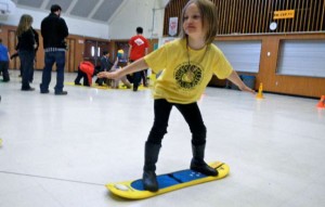 Kindergartner Avalon Newberry is pulled on a snowboard by classmates at the magnet school in Meyers. Photo/Kathryn Reed