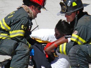 Paramedics lift a victim onto a gurney.