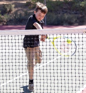 Keiran Born, 7, sends a one-handed backhand across the net. Photo/Carolyn E. Wright/Copyright