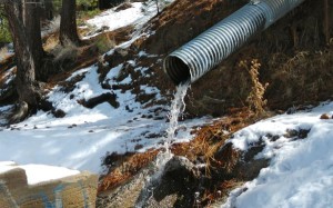 Water flows from the pipe  below the old Alta Mira building in South Lake Tahoe. Photo/LTN file