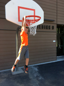 Gantt Miller Jr. hangs from the new basketball hoop at Bijou. Photo/Provided